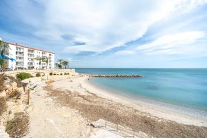 een uitzicht op een strand met een gebouw en de oceaan bij Ametlla by enjoy Rocas Doradas in L'Ametlla de Mar