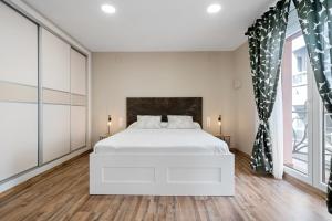 een slaapkamer met een wit bed en een groot raam bij Ametlla by enjoy Rocas Doradas in L'Ametlla de Mar