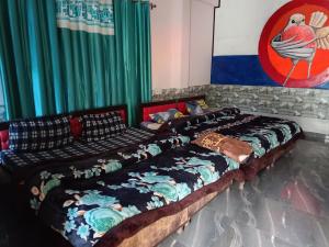 two beds in a room with green curtains at Dog n Hill in Kasol