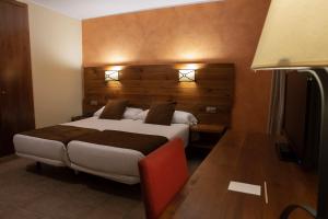 a bedroom with a large bed with a wooden headboard at Hotel Màgic Pas in Pas de la Casa