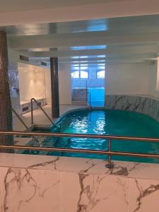 a large swimming pool in a building with a pool at Hôtel Villa Navarre in Pau