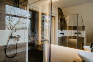 uma casa de banho com um chuveiro e um lavatório. em Peak Hotel & Event em Salzgitter