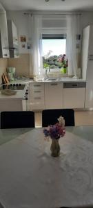 een keuken met een tafel met een vaas met bloemen erop bij Apartment Nena in Krk