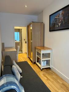 a living room with a couch and a tv on the wall at Fully Equipped Studio in Greenwich - 1 min to Station in London