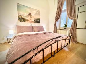 a bedroom with a bed with a painting on the wall at Elegant apartment in Kosice in Košice