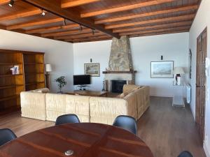 ein Wohnzimmer mit einem Sofa und einem Tisch in der Unterkunft Villa en Sanxenxo a pie de playa, Barreiros in Sanxenxo