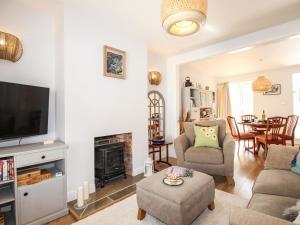 a living room with a tv and a fireplace at Quarrier's Rest in Swanage