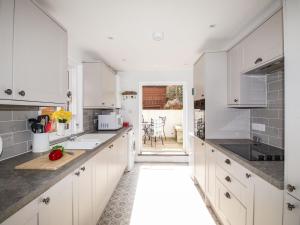 a kitchen with white cabinets and a counter top at Quarrier's Rest in Swanage
