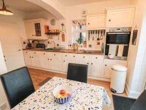 a kitchen with a table with a bowl of fruit on it at Seaside House in Scarborough +8 photos