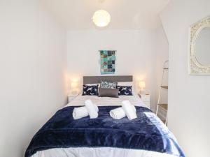 1 dormitorio con 1 cama con manta azul y blanca en Quarrier's Rest, en Swanage