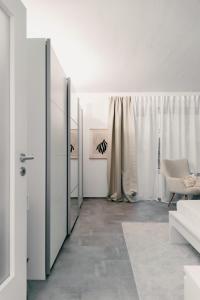 ein weißes Zimmer mit einer Tür und einem Stuhl in der Unterkunft Soulplace Gelsenkirchen - stilvoll & gemütlich in Gelsenkirchen