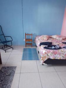 Habitación con 2 camas y alfombra en el suelo en Kitnet Pousada da T, en Pelotas