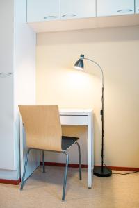 a desk with a chair and a lamp at Hotelli Sointula in Orivesi