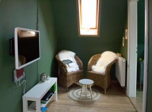 a living room with two chairs and a tv at Villa Kunterbunt - sehr zentral, neu renoviert, 2SZ in Wangen im Allgäu