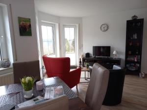 a living room with a table and red chairs at Ferienwohnung Sauerland Fernblick in Olsberg