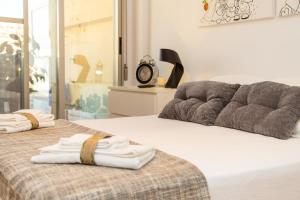 a bedroom with a bed with two towels on it at Cullera Beach Apartment Cap Blanc in Cullera +72 photos