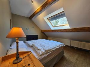 um quarto com uma cama e um candeeiro sobre uma mesa em Spacious holiday home in Wallonie with terrace 