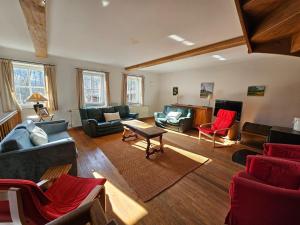 ein Wohnzimmer mit Sofas, Stühlen und einem Tisch in der Unterkunft Spacious holiday home in Wallonie with terrace 