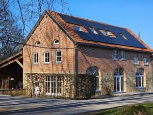 una casa de ladrillo con paneles solares en el techo en Spacious holiday home in Wallonie with terrace, 