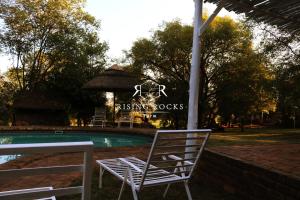 a couple of chairs sitting next to a swimming pool at Relaxing Mountain FarmStay w hikes, boma, pool in Magaliesburg