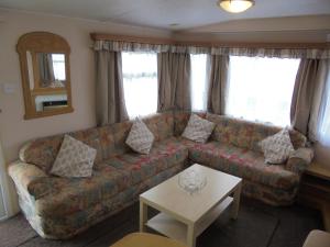 uma sala de estar com um sofá e uma mesa em 8 Berth on Coastfields (Everglade) em Ingoldmells