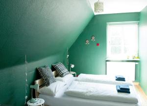 a green bedroom with two beds and a window at Villa Kunterbunt - sehr zentral, neu renoviert, 2SZ in Wangen im Allgäu