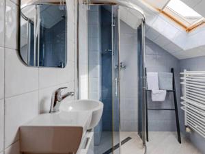 uma casa de banho com um lavatório e um chuveiro em Mesterki em Jastarnia