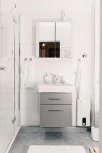 a white bathroom with a sink and a mirror at Soulplace Gelsenkirchen - stilvoll & gemütlich in Gelsenkirchen