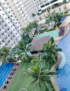 an aerial view of a resort with palm trees and a swimming pool at NJ's Place, Shore 1 Residences, MOA Complex, Pasay City, Philippines in Manila