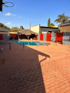 a shadow of a building with a swimming pool at L-PACK PRIMROSe in Germiston