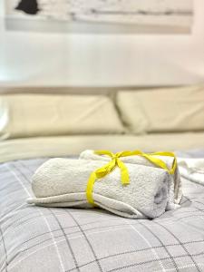 a towel with a yellow ribbon on a bed at B&B Romeo in Bari