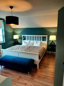 ein Schlafzimmer mit einem weißen Bett und einer blauen Wand in der Unterkunft Glashüttchen mit 2 Schlafzimmern, Sauna und schönem Garten in Annahütte