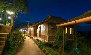 a row of houses at night at Wayanad Village Resort in Koroth