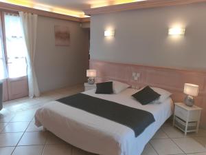 a bedroom with a large white bed with two pillows at LA LAUZERAIE in La Bourboule