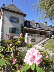 une maison avec des fleurs roses devant elle dans l'établissement LA LAUZERAIE, à La Bourboule