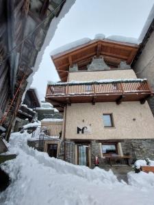 a building with a balcony in the snow at Romantica camera in Valtournenche