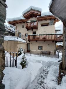 a house with snow on the ground in front of it at Romantica camera in Valtournenche +10 photos