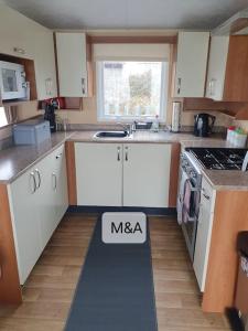 a kitchen with a masa sign on the floor at Slatersaunders56 in Meliden