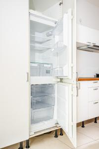 a white refrigerator with its door open in a kitchen at Modern studio apartment in the heart of St Julians in St. Julianʼs