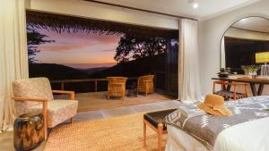 1 dormitorio con 1 cama y balcón con vistas. en Sungulwane Private Game Lodge, en Hluhluwe