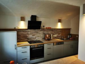 uma cozinha com armários brancos e um forno com placa de fogão em Boardinghouse Wiebke - Ferienwohnung Oldenburg em Oldenburg