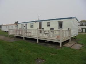 a white mobile home with a porch and a deck at 8 Berth panel heated on Kingfisher Florida in Ingoldmells