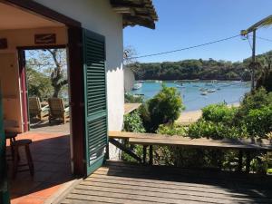 een deur naar een huis met uitzicht op een rivier bij Ossos Beach House in Búzios