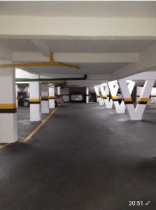 an empty parking garage with a parking lot with cars at Apt Guarujá Enseada lado praia FAN 1 dorm Tv Netflix Wi-Fi Ar até 5 pessoas in Guarujá