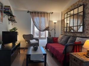 uma sala de estar com um sofá vermelho e uma televisão em Vieille Ville 2 - La Petite Maison à Safranier, 2 bedrooms, max 4 adults and 2 kids em Antibes