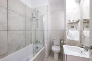 een badkamer met een douche, een toilet en een wastafel bij Solaar Apartments Faneromeni in Larnaka