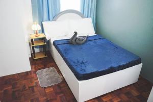 a bedroom with a bed with a snake sitting on it at CosiHome Guesthouse in Laguna