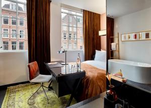 a hotel room with a bed and a desk and a tub at Sir Albert Hotel, part of Sircle Collection in Amsterdam