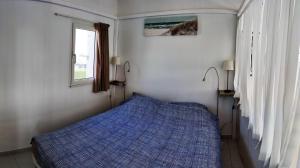 um quarto com uma cama azul e uma janela em Villa Village Naturiste Nirvana em Cap d'Agde