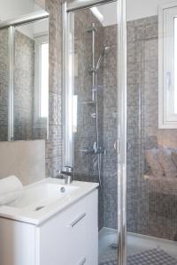 a white bathroom with a shower and a sink at Solaar Apartments Faneromeni in Larnaka